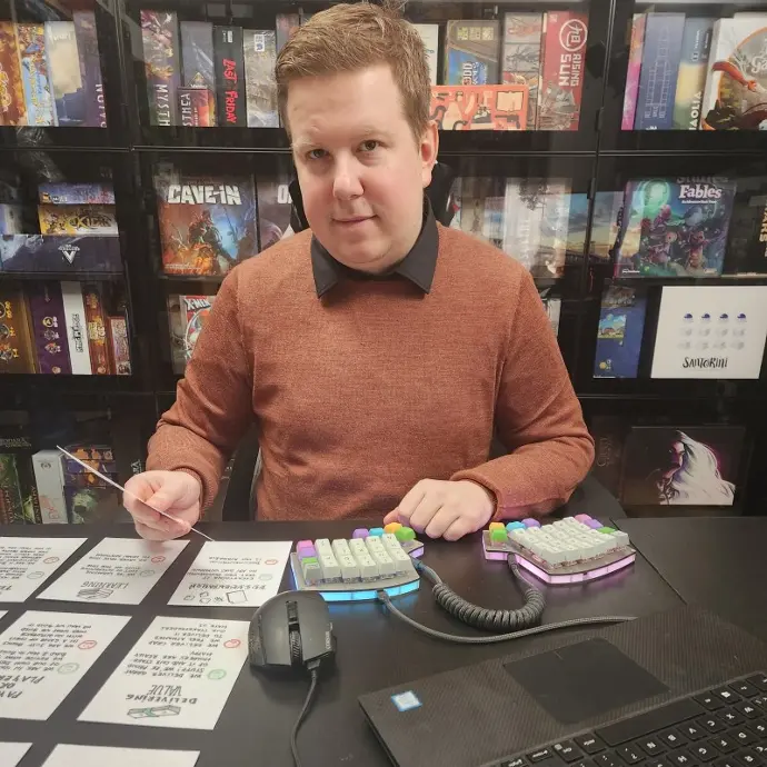 Un homme ayant un clavier personnalisé et souriant à l'appareil photo.